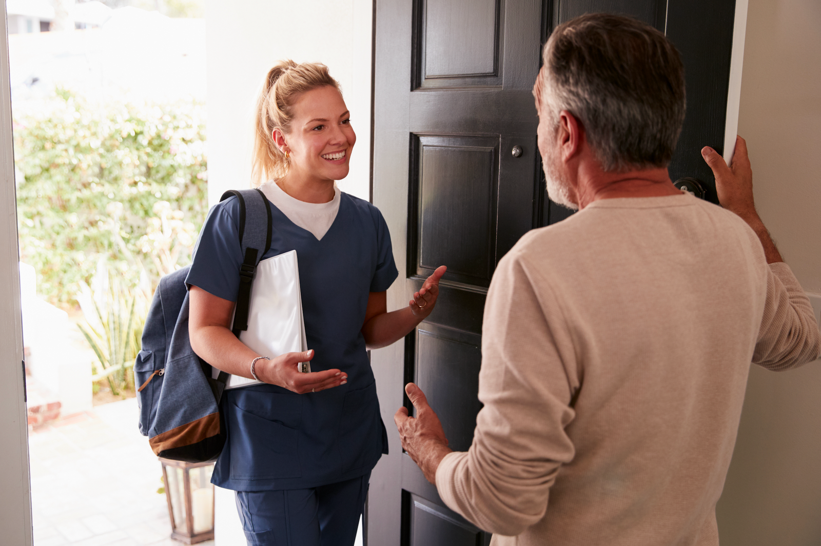 A licensed nurse entering a patient’s home for an in-home care visit, representing House Call The App’s convenient, on-demand nursing services available across South Florida.